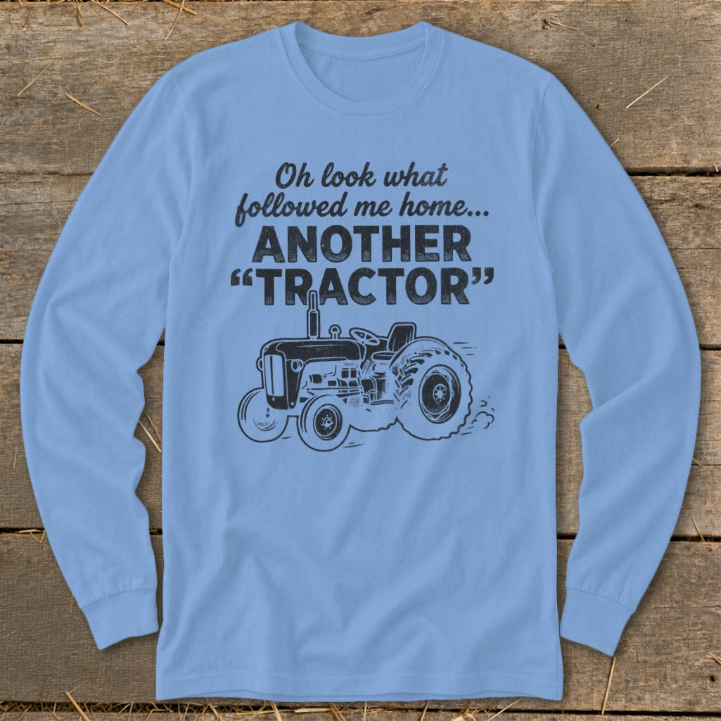 Light blue long-sleeve shirt with tractor graphic and text "Oh look what followed me home... ANOTHER 'TRACTOR'".