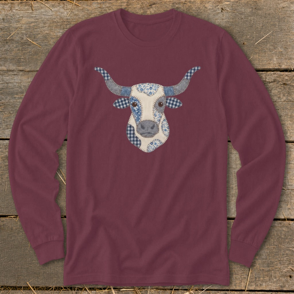 Maroon long-sleeve shirt featuring a patchwork bull's head graphic with blue gingham and floral patterns.