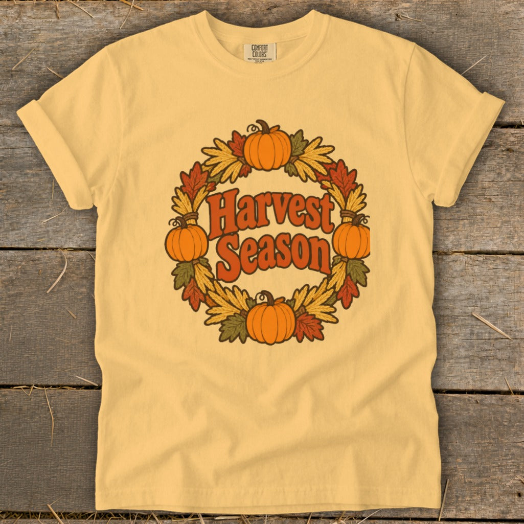 Yellow t-shirt with a "Harvest Season" text and pumpkin wreath graphic.