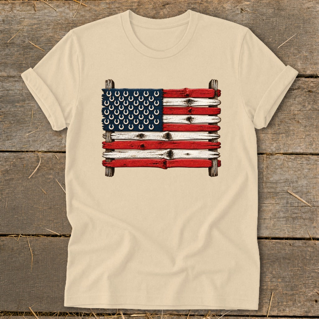 Beige crewneck t-shirt featuring a graphic of the American flag made of weathered wooden planks and horseshoes.