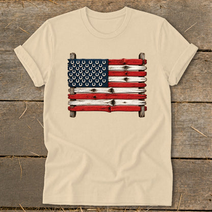 Beige crewneck t-shirt featuring a graphic of the American flag made of weathered wooden planks and horseshoes.