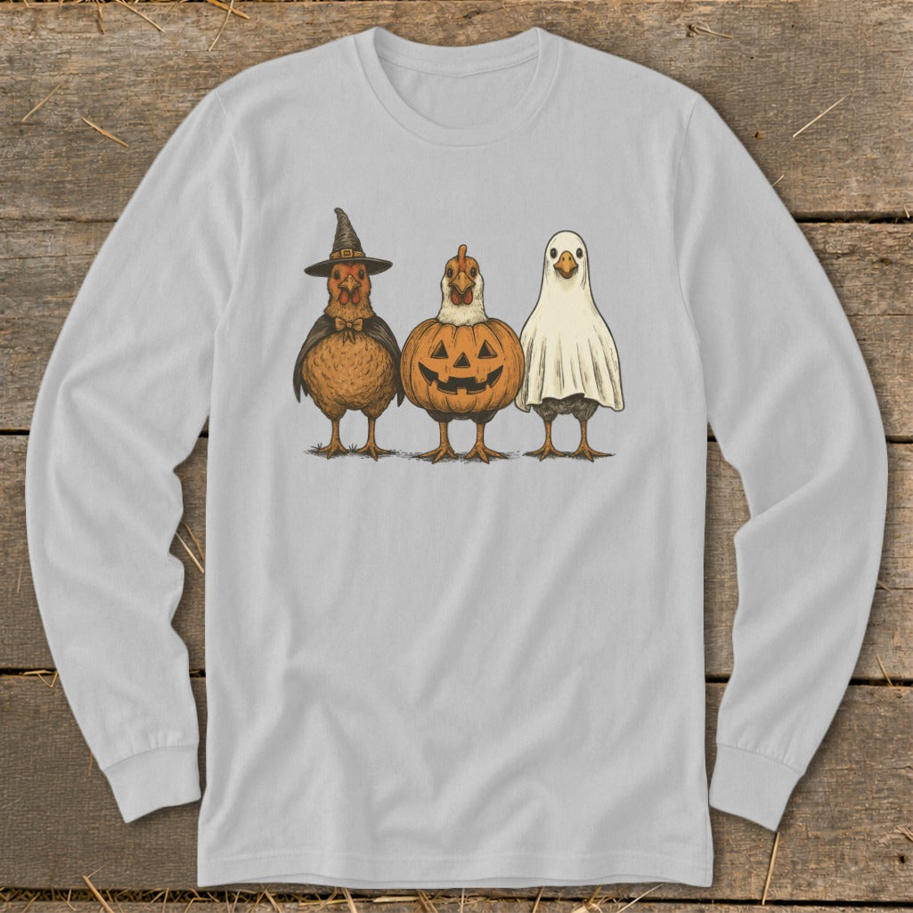 Three chickens dressed in Halloween costumes: witch, pumpkin, and ghost.