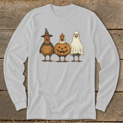 Three chickens dressed in Halloween costumes: witch, pumpkin, and ghost.