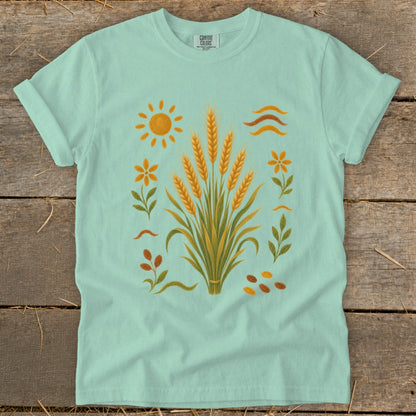 Mint t-shirt with illustration of wheat stalks, sun, flowers, and leaves.