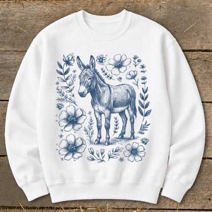 White sweatshirt with a blue sketched donkey surrounded by floral and leafy vines.
