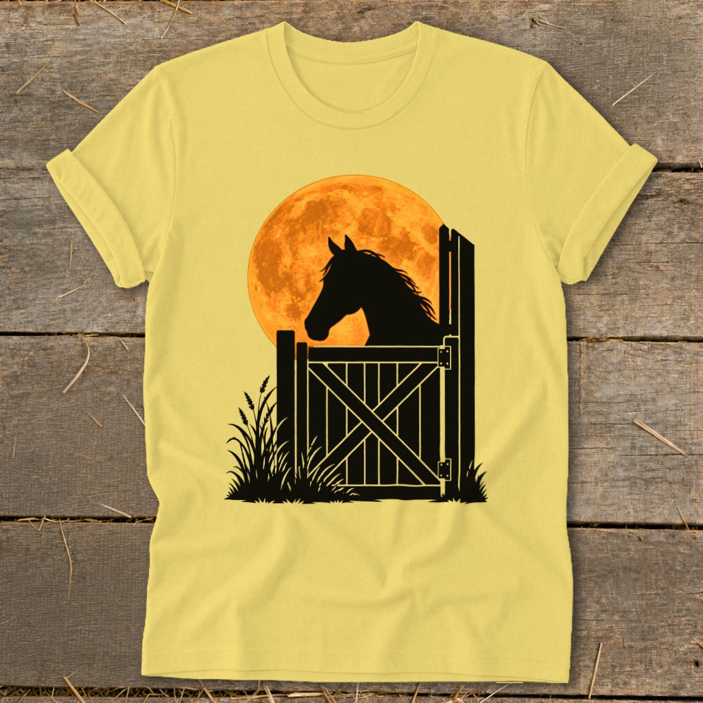 A yellow t-shirt features a black silhouette of a horse looking over a stable door against a large orange moon.