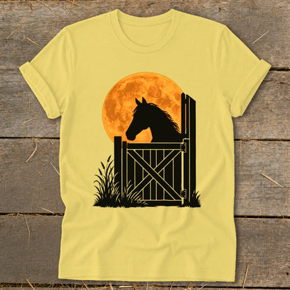 A yellow t-shirt features a black silhouette of a horse looking over a stable door against a large orange moon.