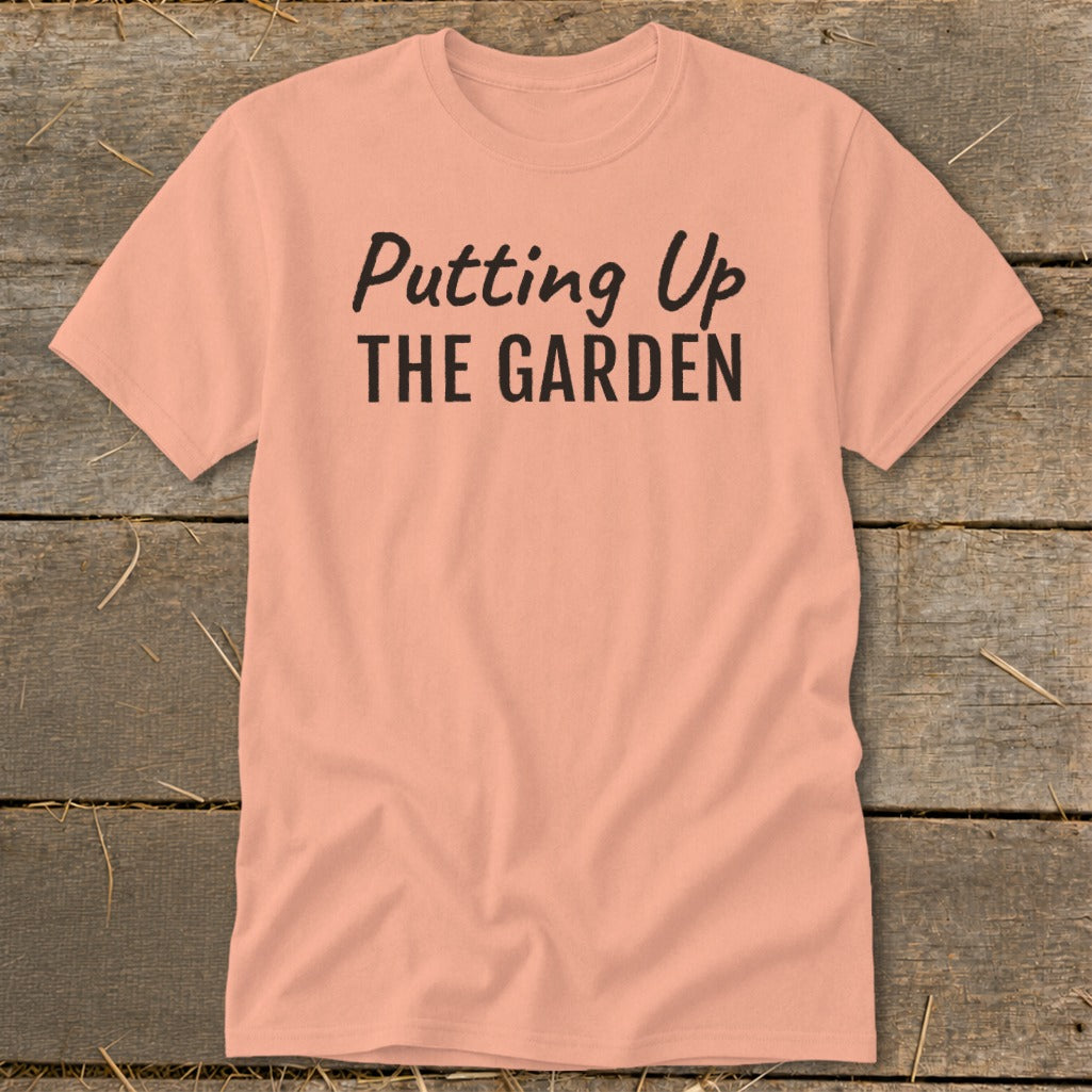 Peach t-shirt with "Putting Up THE GARDEN" in black text.