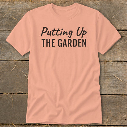 Peach t-shirt with "Putting Up THE GARDEN" in black text.