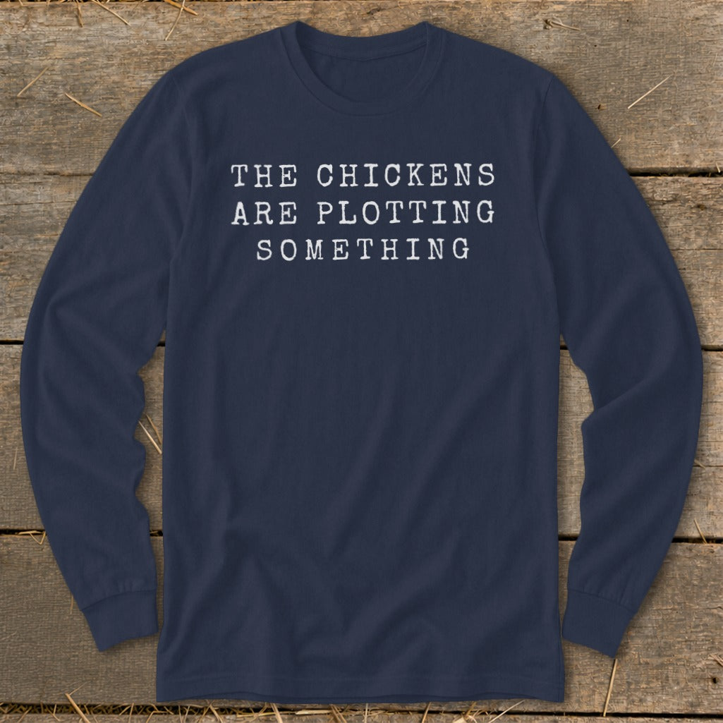 Navy long-sleeve shirt with white text reading "THE CHICKENS ARE PLOTTING SOMETHING."