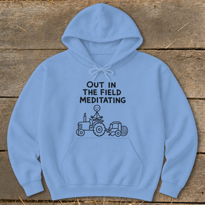 Light blue hoodie with black text and drawing of stick figure meditating on a tractor.