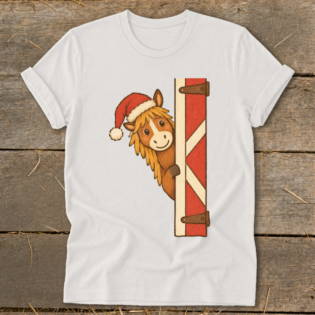 Horse wearing a Santa hat peeking from a red barn door.