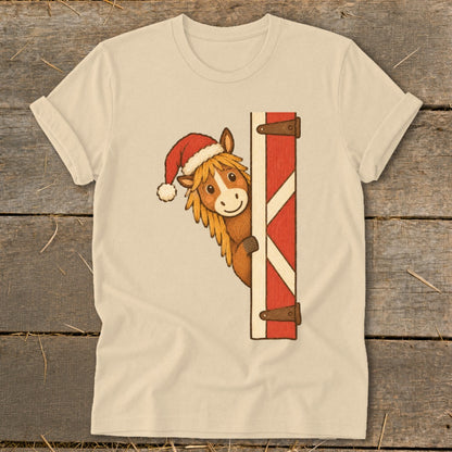 Tan t-shirt with a horse wearing a Santa hat peeking from a barn door.