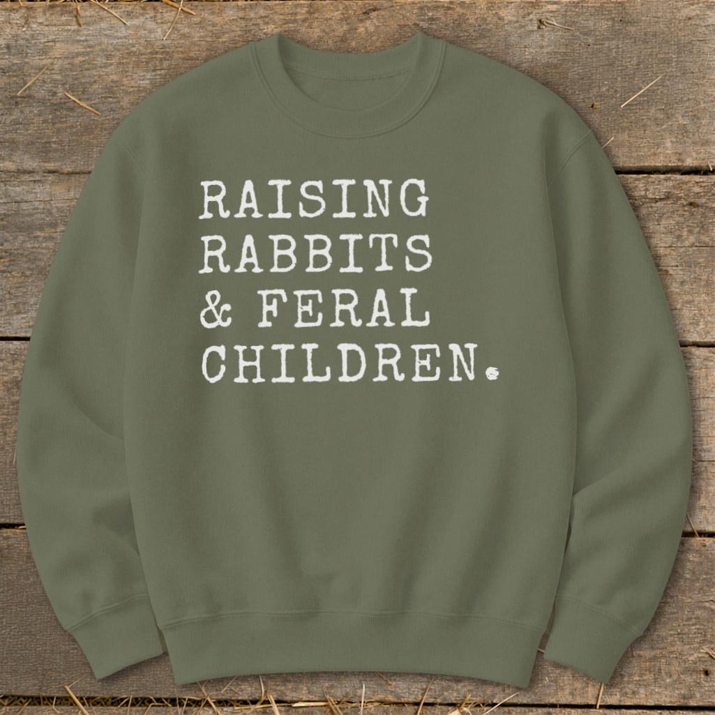 Olive green sweatshirt with white text: "RAISING RABBITS & FERAL CHILDREN."