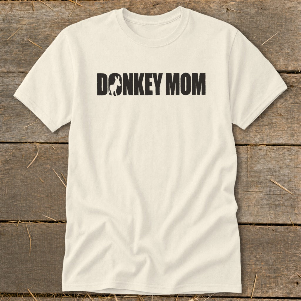 An off-white t-shirt featuring the black text DONKEY MOM with a silhouette of a donkey replacing the letter O.