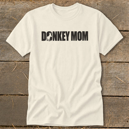 An off-white t-shirt featuring the black text DONKEY MOM with a silhouette of a donkey replacing the letter O.