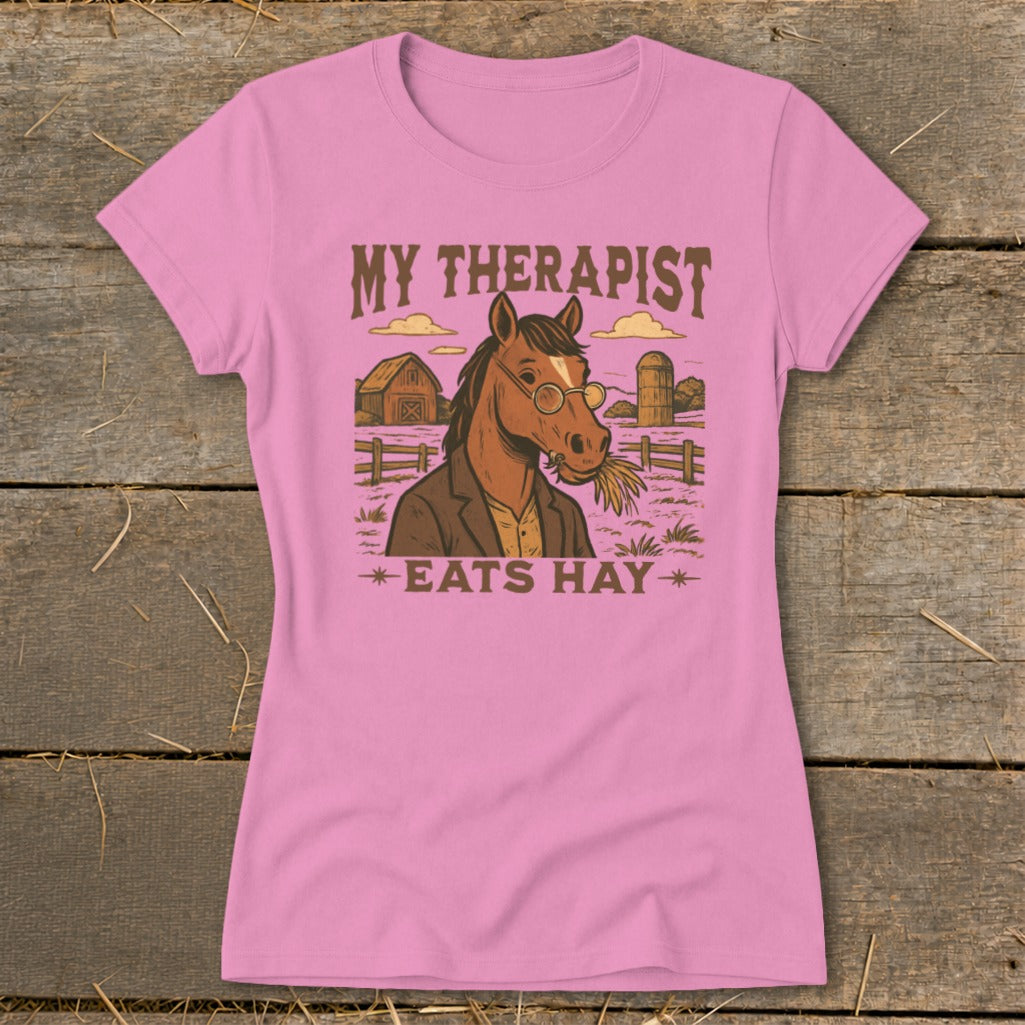 Pink t-shirt with illustration of a horse wearing glasses and eating hay.