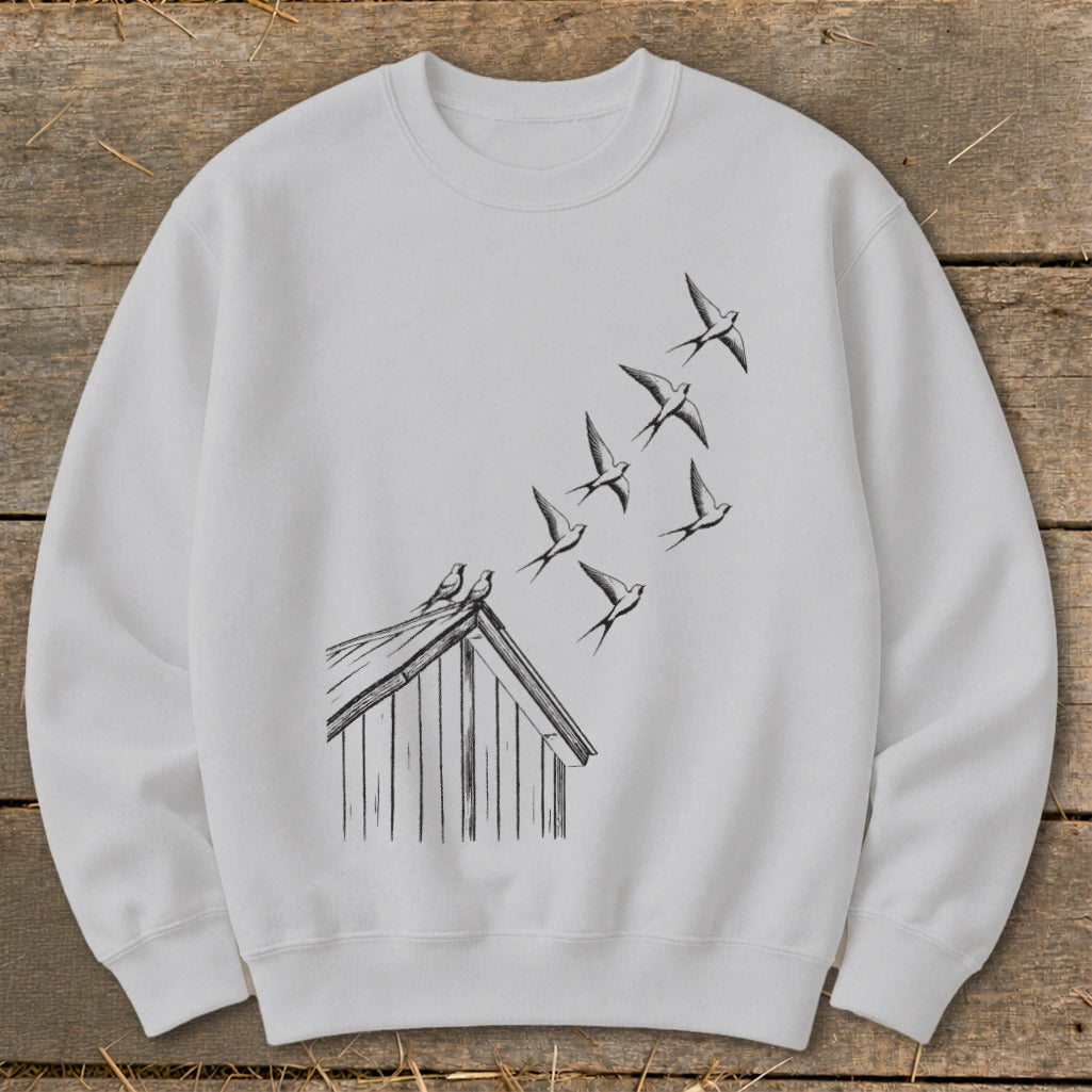 Light grey crewneck sweatshirt featuring a black ink sketch of birds flying from a rooftop.