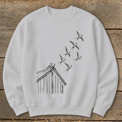 Light grey crewneck sweatshirt featuring a black ink sketch of birds flying from a rooftop.
