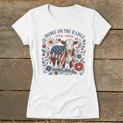 White t-shirt with cow graphic featuring American flag, flowers, and text "HOME ON THE RANGE 1776-2026".