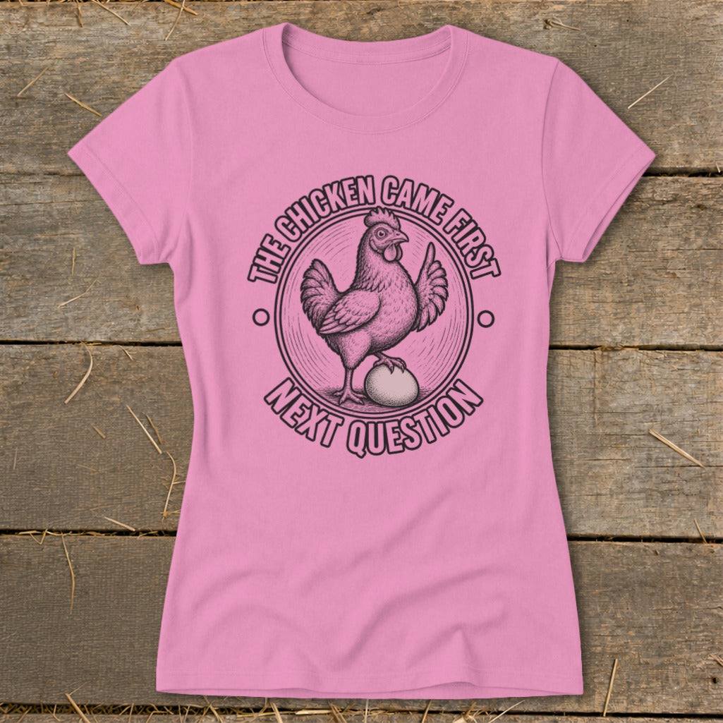 Pink t-shirt with a chicken and egg graphic and text "The chicken came first next question."