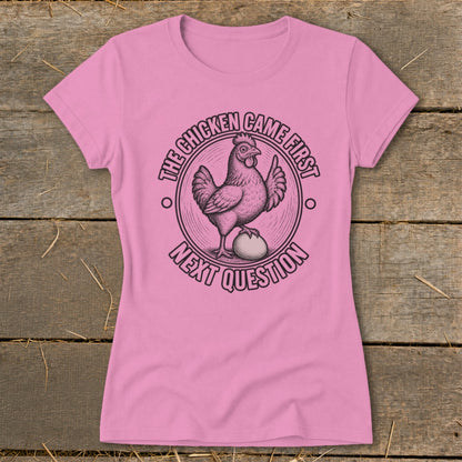 Pink t-shirt with a chicken and egg graphic and text "The chicken came first next question."