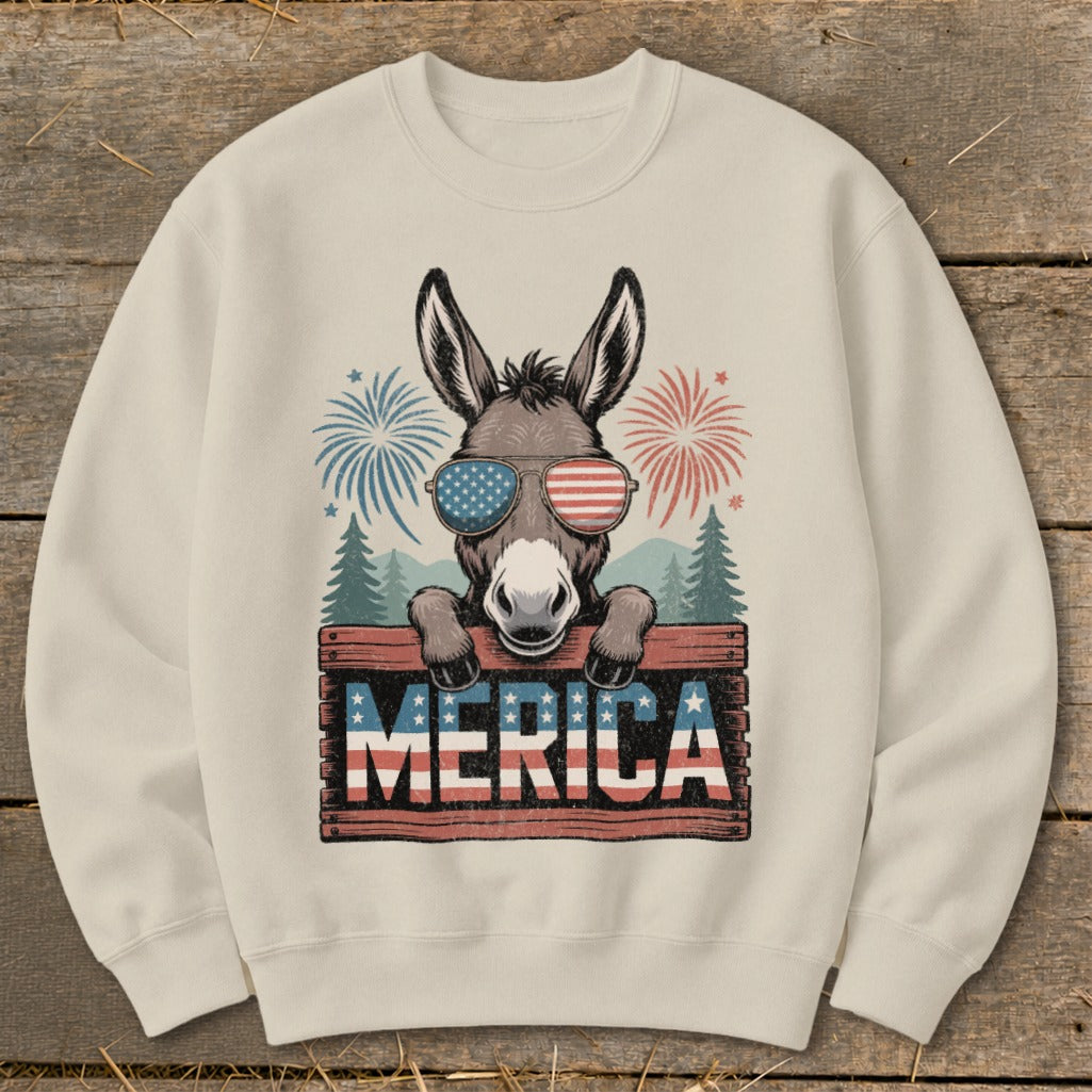 Donkey in sunglasses with "MERICA" text and fireworks on a cream sweatshirt.