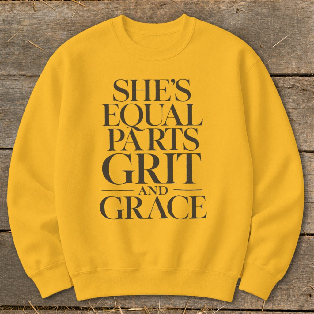 Yellow sweatshirt with black text "SHE'S EQUAL PARTS GRIT AND GRACE".