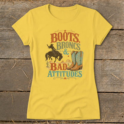 Yellow t-shirt with "Boots, Broncs & Bad Attitudes" graphic featuring cowboy boots and rodeo rider.