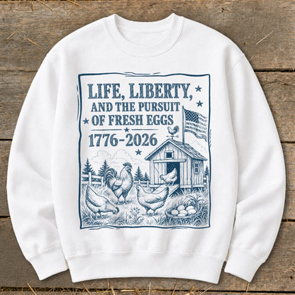 White sweatshirt with "Life, Liberty, and the Pursuit of Fresh Eggs 1776-2026" graphic.