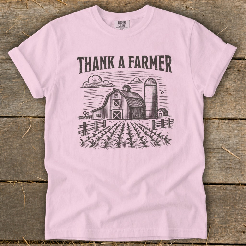 Pink t-shirt with "Thank a Farmer" text and farm graphic.