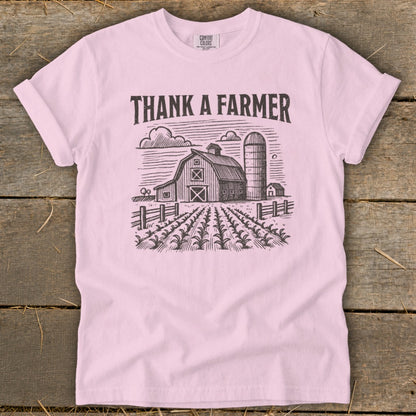 Pink t-shirt with "Thank a Farmer" text and farm graphic.