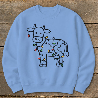 Light blue sweatshirt with a black line drawing of a cow wrapped in colorful Christmas lights.
