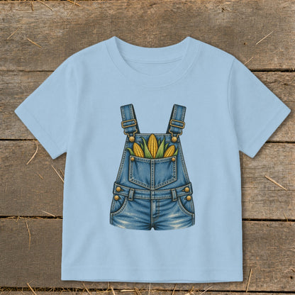 Light blue t-shirt with denim overalls graphic featuring corn ears in the pockets.