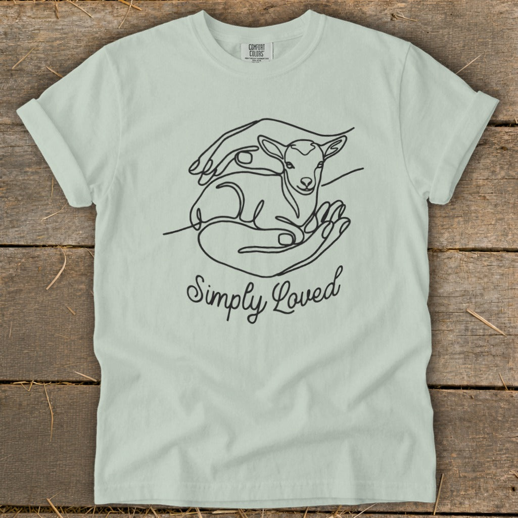 Light green t-shirt with line art of a lamb in hands and text "Simply Loved".