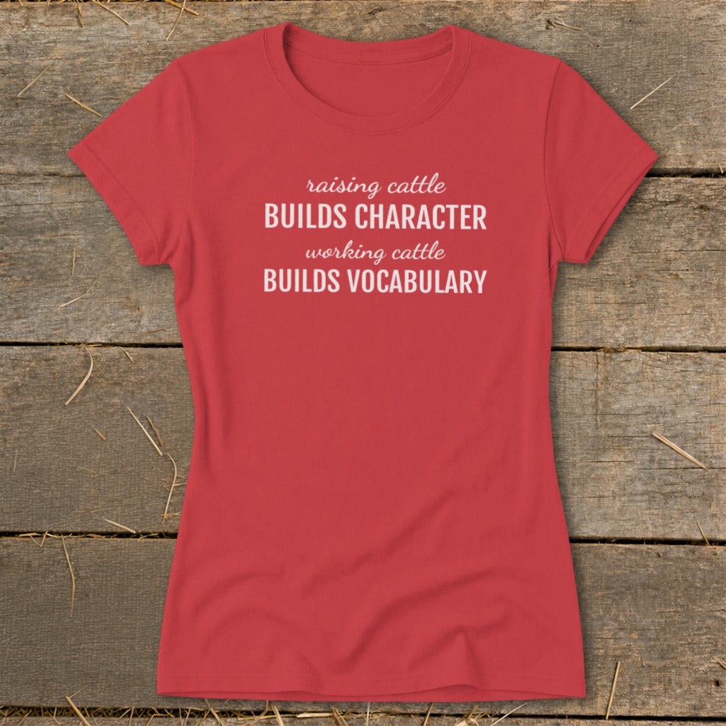 Red t-shirt with white text "raising cattle BUILDS CHARACTER working cattle BUILDS VOCABULARY".