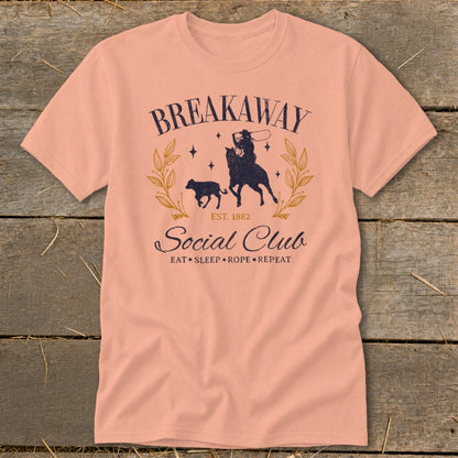 Peach t-shirt with "Breakaway Social Club" text and a cowboy roping a calf graphic.