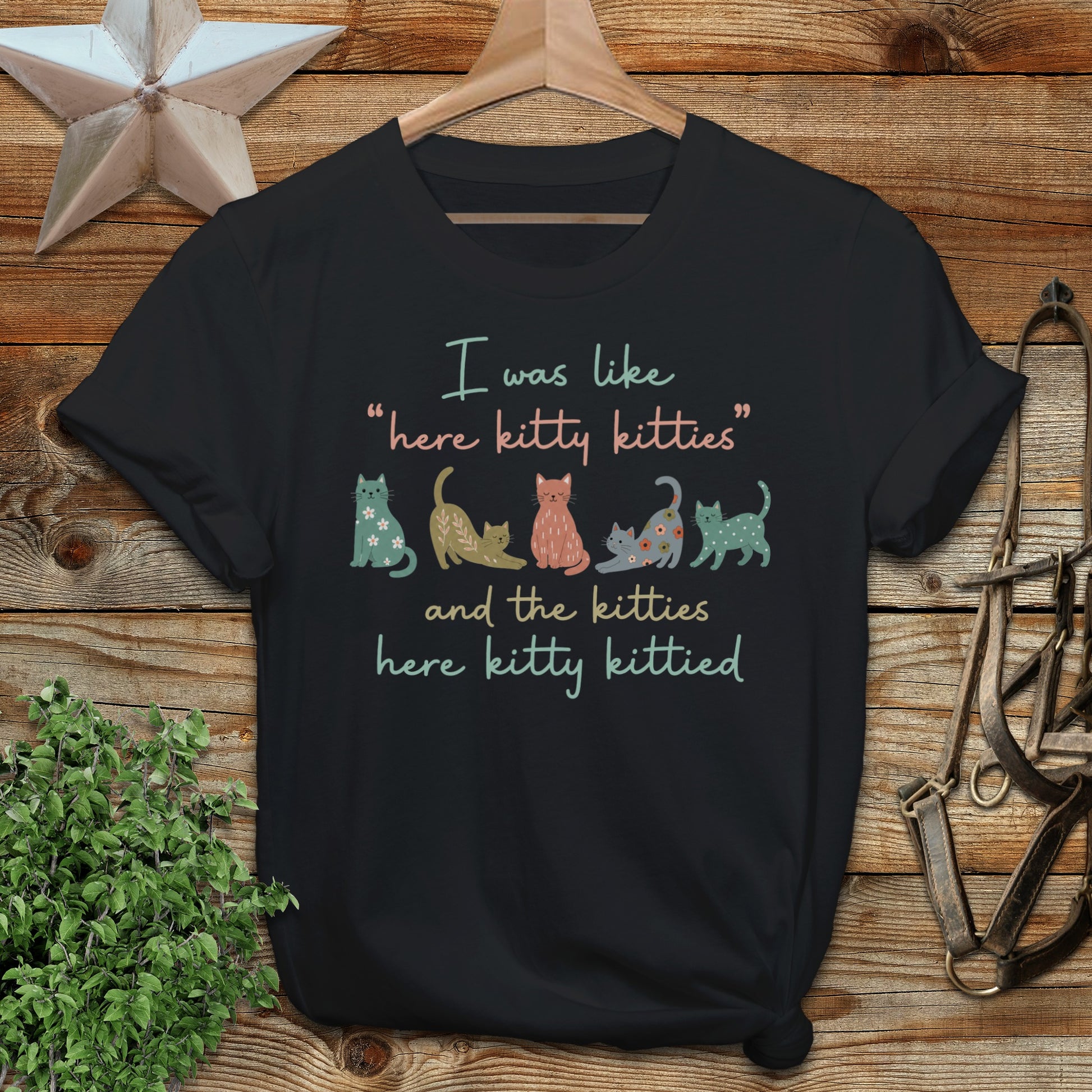 T-shirt with "here kitty kitties and the kitties here kitty kittied" and colorful cartoon cats.