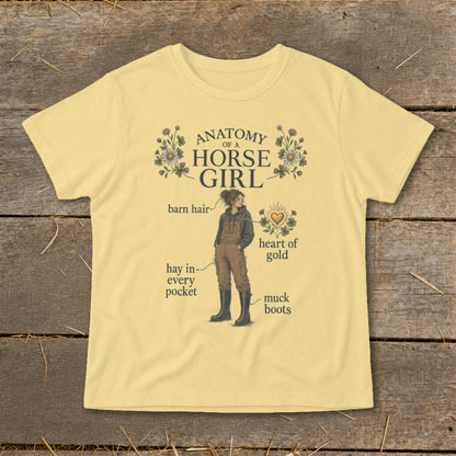 Yellow t-shirt with "Anatomy of a Horse Girl" graphic, showing a girl with barn hair, hay, and muck boots.