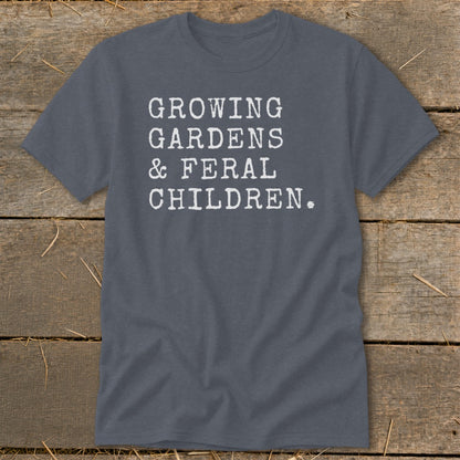Grey t-shirt with white text reading "GROWING GARDENS & FERAL CHILDREN."
