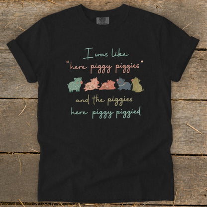 Black t-shirt with "I was like 'here piggy piggies' and the piggies here piggy piggied" text and cartoon pigs.