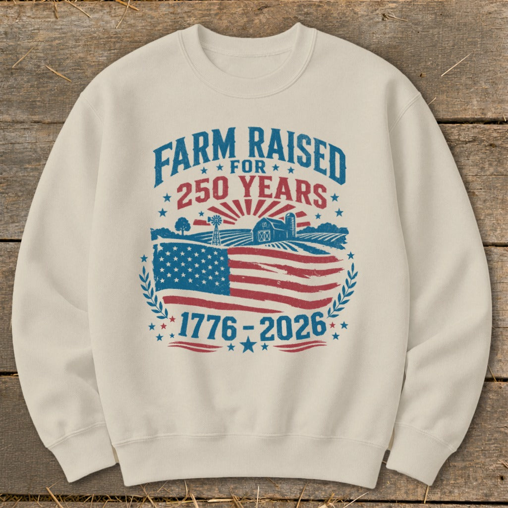 Cream sweatshirt with "Farm Raised for 250 Years 1776-2026" and American flag graphic.