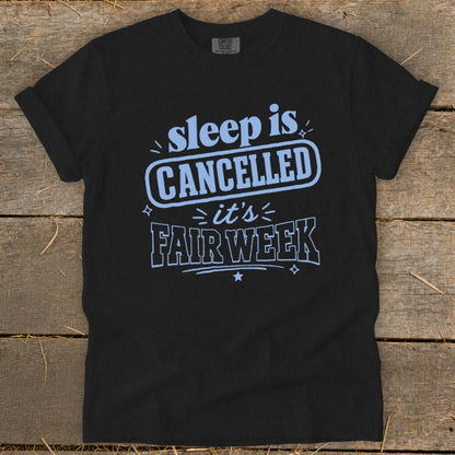 Black t-shirt with light blue text that reads "sleep is CANCELLED it's FAIR WEEK".