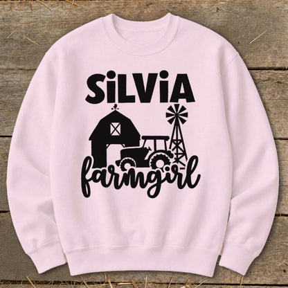 Pink sweatshirt with "SilVia farmgirl" text and barn, tractor, and windmill graphic.