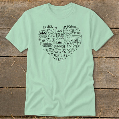Light green t-shirt with a black heart-shaped design of chickens, coop, and farm life text.