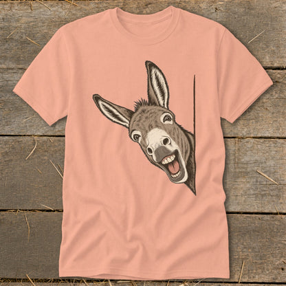 Peach t-shirt with a cartoon donkey peeking around a corner with a wide smile.