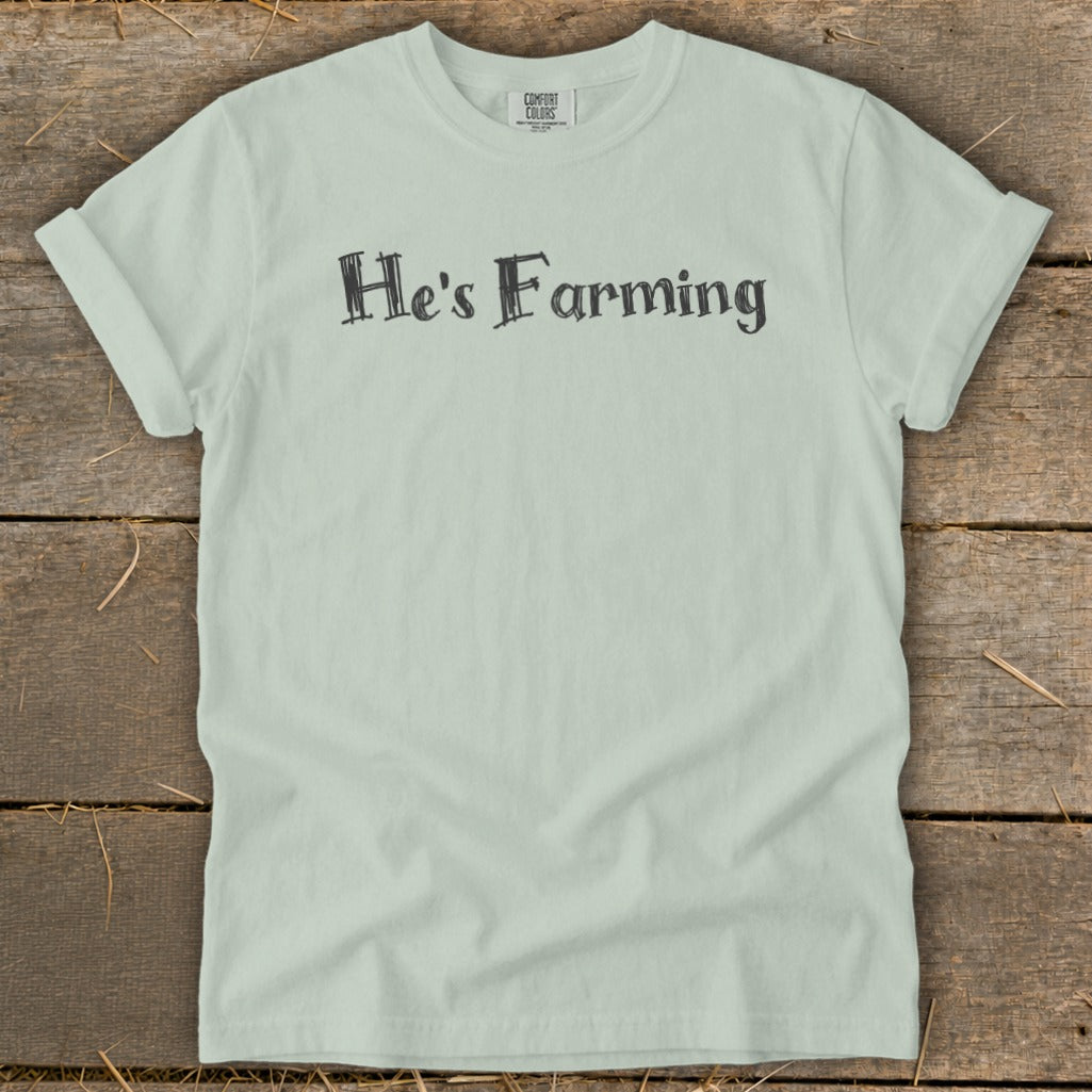 Light green t-shirt with black text "He's Farming" and Comfort Colors label.