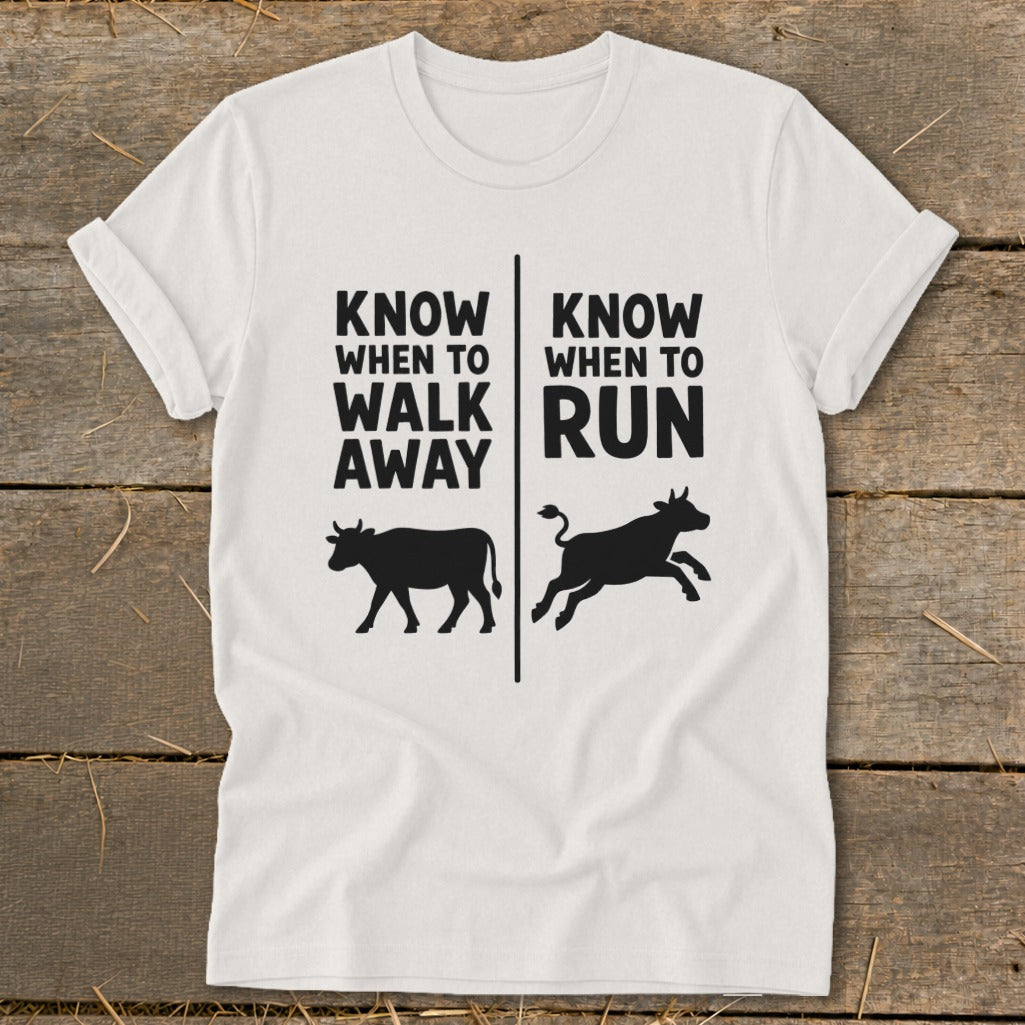 White t-shirt with text "KNOW WHEN TO WALK AWAY" and "KNOW WHEN TO RUN" and cow graphics.