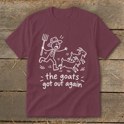 Maroon t-shirt with white line drawing of farmer chasing goats, text "the goats got out again".