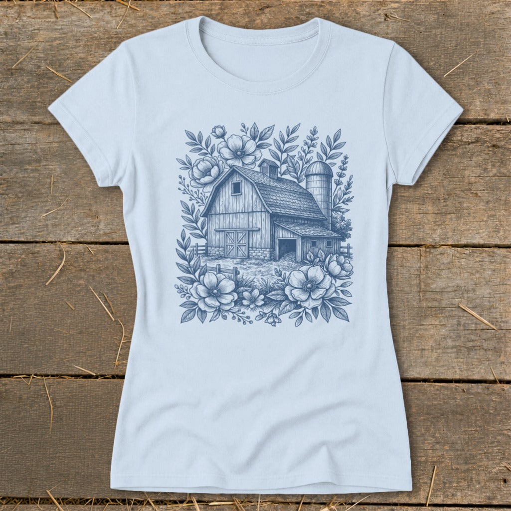 Light blue t-shirt with a blue line drawing of a barn and silo surrounded by flowers.